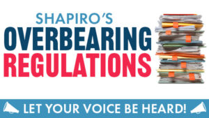 Stack of folders overflowing with paper, bullhorns and text reading “Shapiro’s Overbearing Regulations. Let your voice be heard.”